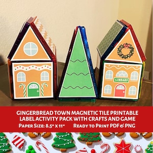 May include: Three colourful magnetic tile structures: two gingerbread houses and a Christmas tree. The gingerbread houses are orange with white trim and feature doors, windows, and a wreath. The tree is green. The text reads "GINGERBREAD TOWN MAGNETIC TILE PRINTABLE LABEL ACTIVITY PACK WITH CRAFTS AND GAME".