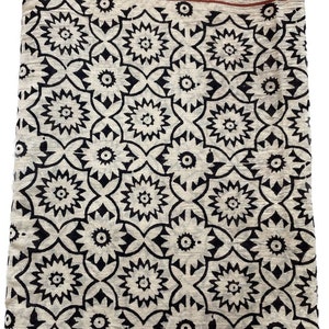 May include: A white cotton fabric with a black and red block print pattern. The fabric has a geometric design with a repeating pattern of flowers.