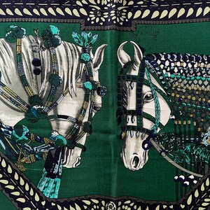 Peut inclure: Foulard en soie vert repr&eacute;sentant deux chevaux blancs orn&eacute;s de harnais &eacute;labor&eacute;s et d'&eacute;l&eacute;ments d&eacute;coratifs. Les chevaux se d&eacute;tachent sur un fond vert fonc&eacute;, encadr&eacute;s par une bordure &agrave; motifs bleu marine et cr&egrave;me.