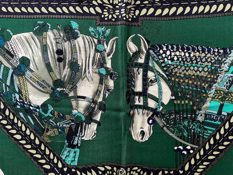 Peut inclure: Foulard en soie vert repr&eacute;sentant deux chevaux blancs orn&eacute;s de harnais &eacute;labor&eacute;s et d'&eacute;l&eacute;ments d&eacute;coratifs. Les chevaux se d&eacute;tachent sur un fond vert fonc&eacute;, encadr&eacute;s par une bordure &agrave; motifs bleu marine et cr&egrave;me.