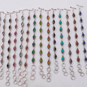 May include: A set of 12 silver bracelets featuring various coloured gemstone beads. Each bracelet has a lobster clasp fastening and a silver chain.
