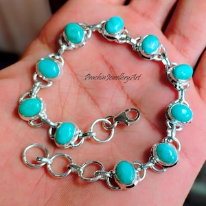 May include: A silver bracelet featuring oval turquoise stones. The stones are set in individual bezels and connected by silver links. The bracelet has a lobster clasp closure. The text "PrachinJewelleryArt" is visible.