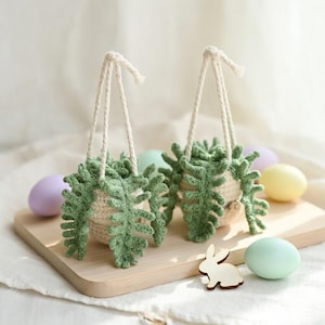 May include: A set of three ceramic mugs with a speckled, matte finish. The mugs are in shades of cream, light gray, and dark gray. Each mug has a simple, minimalist design and a rounded handle. The mugs are likely for coffee or tea.