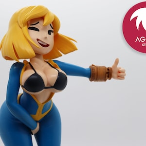 Puede incluir: Una figura de plástico azul y amarilla de una mujer con cabello rubio que lleva un mono azul y un top de bikini negro. Está haciendo un pulgar hacia arriba con su mano derecha. La figura está hecha de plástico y mide aproximadamente 25 cm de alto.