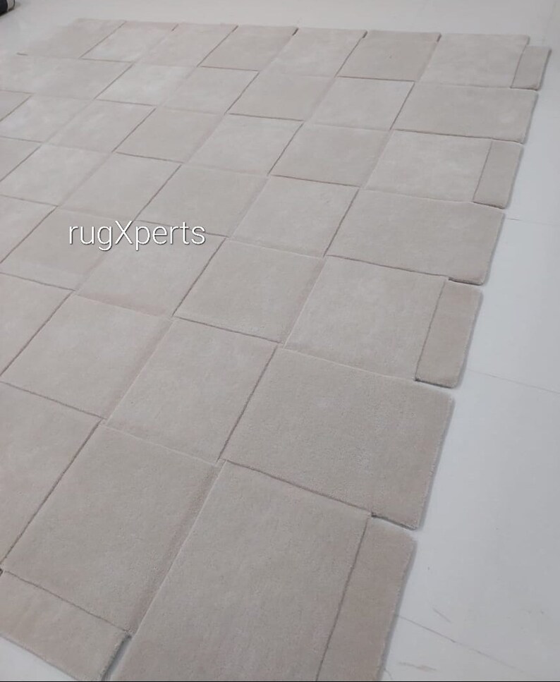 Pu&ograve; includere: Un grande tappeto modulare di colore grigio chiaro composto da quadrati singoli. Il tappeto &egrave; composto da 16 quadrati ed &egrave; disposto a griglia. Il tappeto si chiama "rugXperts".