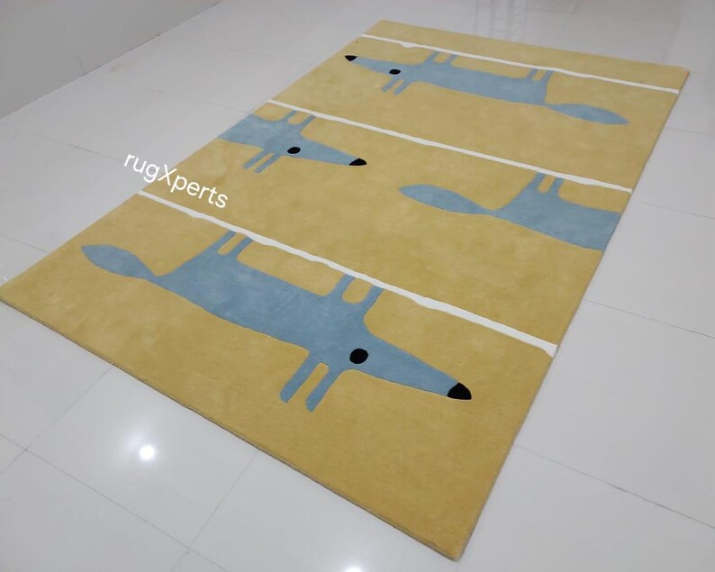 May include: A yellow rug with a repeating pattern of blue stylized foxes. The rug has white lines running across it.
