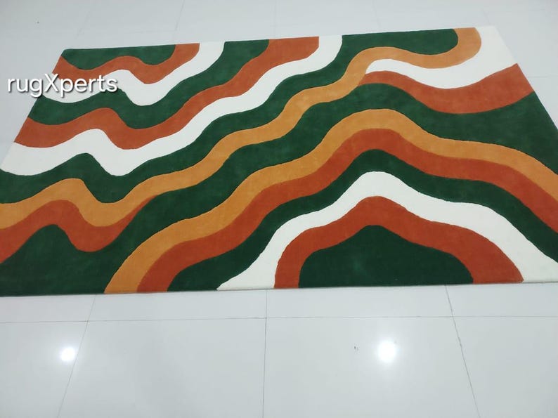 May include: A rectangular rug with a wavy pattern in shades of green, orange, white, and rust. The rug's design features flowing, organic lines that create a visually appealing and modern aesthetic. The rug is suitable for living rooms and bedrooms.