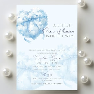 Puede incluir: Una invitación a un baby shower con un diseño de acuarela azul claro. La invitación presenta una nube en forma de corazón con un lazo y el texto "A Little Peace of Heaven Is On The Way!". Detalles: nombre, fecha, hora y lugar.