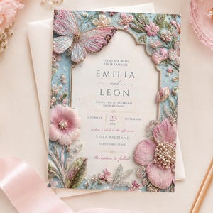 Premium high-quality editable butterfly wedding invitation featuring embroidered blush pink florals, delicate botanical details, pearl accents, and a soft powder blue background with an elegant gold arch frame. Luxury Canva template perfect for romantic, garden, spring, and elegant weddings.