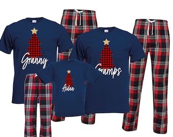 May include: A set of four matching pajamas featuring a red and black plaid pattern with a gold star and a red and black plaid Christmas tree. The pajamas have the words "Granny", "Gramps", and "Aidan" printed on them.