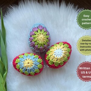 Three crocheted Easter eggs in pink, green, and blue with a white center. The eggs are on a white fluffy surface. Easy crochet pattern, detailed row-by-row instructions with photos, written in US & UK terms.