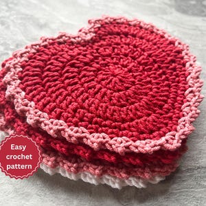 Peut inclure: Un dessous de plat en forme de cœur crocheté dans des tons de rose et de rouge avec une bordure blanche. Le dessous de plat est composé de plusieurs couches de fils roses et rouges. Le texte "Easy crochet pattern" est sur un cercle rouge.