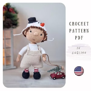 May include: Crochet pattern PDF in English for a cute amigurumi doll wearing a snowman hat and holding a small Christmas tree. The doll is wearing overalls and red and white checkered socks. The pattern includes instructions for making the doll, hat, tree, and a small red car.