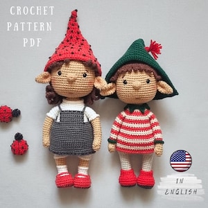 May include: Two crocheted dolls with elf-like features, wearing hats and outfits. One doll has a red hat with black dots and a gray overall dress. The other doll has a green hat and a red and white striped shirt. The words "CROCHET PATTERN PDF" and "IN ENGLISH" are visible.