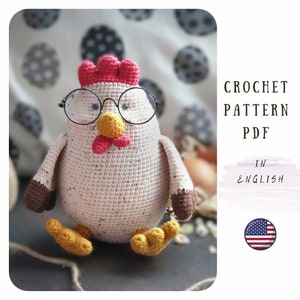 May include: Crochet pattern PDF in English for a white crocheted chicken wearing glasses with a red comb and brown feet. The pattern includes instructions for making the chicken with yarn and a crochet hook.