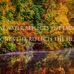 May include: A quote from Proverbs 27:19, "As water reflects the face, so one's life reflects the heart." The quote is displayed over a scenic image of a pond surrounded by trees with vibrant fall foliage.