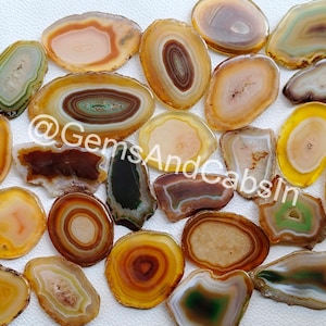 May include: Assortment of agate slices in various shades of brown, yellow, and green. The agate slices have a natural, polished finish and are perfect for crafting or decoration.