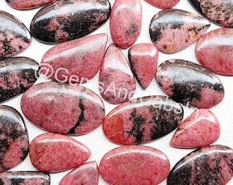 Puede incluir: Una colección de 18 cabujones de piedras preciosas rosas y negras. Los cabujones son de varias formas y tamaños, algunos tienen una forma más ovalada y otros una forma de lágrima. Los cabujones están todos pulidos y tienen un acabado liso y brillante.