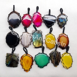 Op de afbeelding: Assortiment van 15 edelsteen hangers met zwarte koordwikkelingen. De hangers zijn in verschillende vormen en kleuren, waaronder zwart, wit, grijs, rood, roze, geel, oranje, groen en blauw.