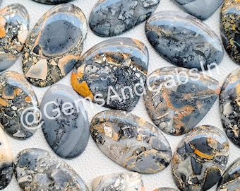 May include: A collection of 14 oval-shaped, polished, natural stone cabochons. The stones are a mix of gray, black, and orange with a speckled pattern. The stones are approximately 1 inch in length.