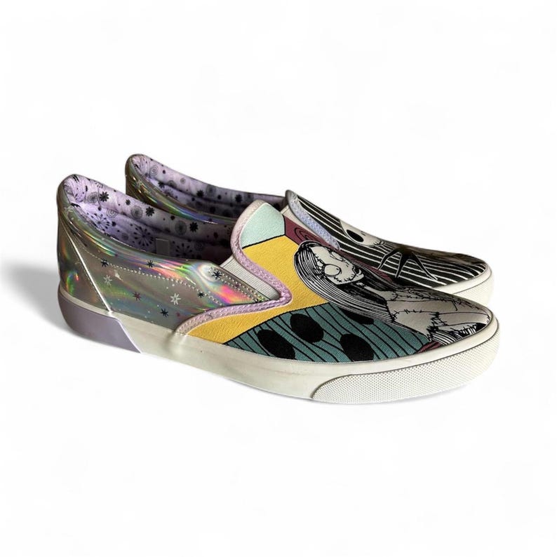 May include: Pair of slip-on sneakers featuring a colorful design inspired by a movie. The shoes have a white sole, a yellow and teal upper, and a black and white striped design on the toe. The heel is clear with a holographic effect.