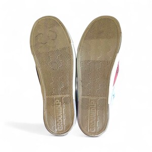 May include: Pair of canvas sneakers with the soles facing up, revealing the tread pattern and the size 11. The brand name "GROUND UP" is printed on the soles. The sneakers have a white rubber trim.
