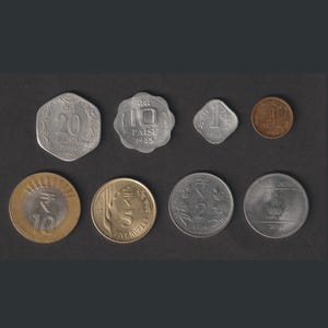 May include: A collection of eight Indian coins, including 1, 5, 10, 20, and 25 Rupee coins, as well as 1, 10, and 20 Paise coins.