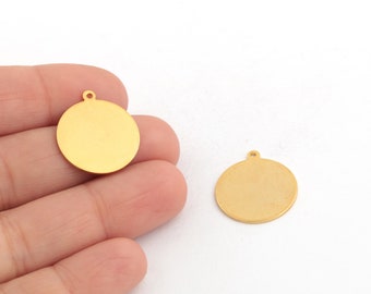 May include: Two gold-colored metal circle charms with a small loop at the top. The charms are blank and ready for personalization.