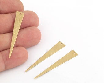 May include: Three gold-colored metal triangle shapes with a hole at the top. The triangle shapes are pointed at the bottom and have a hammered texture.