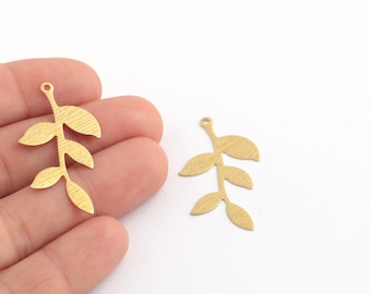May include: Two gold-colored metal leaf branch charms with a textured surface. Each charm has a loop at the top for attaching to jewelry or other crafts.