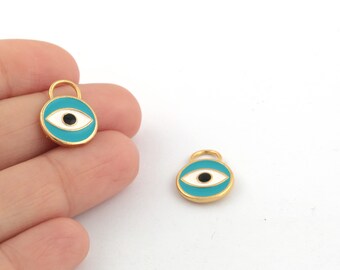 Puede incluir: Dos abalorios de color dorado con un diseño de ojo turco de esmalte azul. Los abalorios tienen un ojo blanco con una pupila negra.