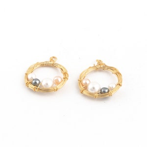May include: Two gold wire circles with white, pink, and gray pearls attached. The circles are about 1 inch in diameter.