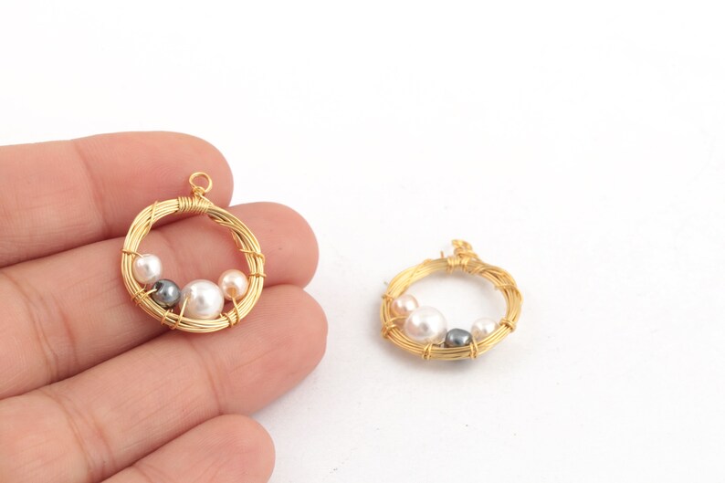 May include: Two gold wire circles with a pearl and gray bead design. The circles are about 1 inch in diameter.