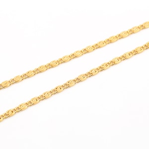 Könnte beinhalten: Eine goldene Kettenkette mit einem zarten, gemusterten Design. Die Kette besteht aus kleinen, miteinander verbundenen ovalen Formen.