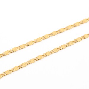 Könnte beinhalten: Eine goldene Kettenkette mit einem zarten, strukturierten, ovalen Gliederdesign.