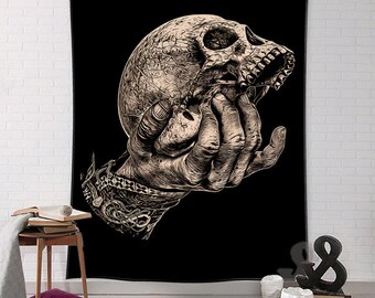 Può includere: Un arazzo nero con una mano che tiene un teschio dettagliato. Il teschio è di colore marrone chiaro e ha una superficie testurizzata. La mano è anche di colore marrone chiaro e ha una texture dettagliata.