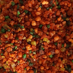 Può includere: Primo piano di un mix di pezzi di resina rossa, verde e gialla. La resina viene utilizzata per l'incenso e ha una varietà di dimensioni e forme.
