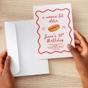 Op de afbeelding: Een witte verjaardagsuitnodiging met een rode golvende rand, voorzien van een hotdog-illustratie en de tekst: a weenie bit older, EST. 1995, Jane's 30th Birthday, Sunday, June 14 2025, 7PM-9PM, 123 Anywhere St., Any City, RSVP by June 10 to Kim, 123-456-7890.