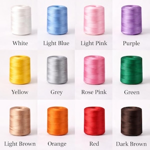 May include: A collection of colorful spools of thread, each labeled with its color: White, Light Blue, Light Pink, Purple, Yellow, Grey, Rose Pink, Green, Light Brown, Orange, Red, and Dark Brown. Ideal for sewing and crafting projects.