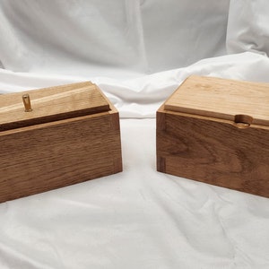 May include: Two wooden boxes with lids. The box on the left has a brass knob on the lid. Both boxes are made of light brown wood with a natural finish.