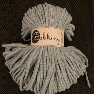 May include: A skein of light blue cotton cord, approximately 5mm thick, labeled "Bobbiny Premium String".