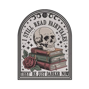 May include: Embroidered patch with a gothic theme. The design features a skull atop a stack of books, a red rose, and the text "I STILL READ FAIRYTALES THEY'RE JUST DARKER NOW" in a decorative arch.