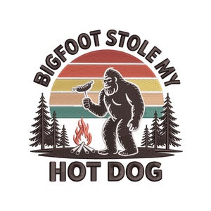 May include: Embroidered design featuring Bigfoot holding a hot dog, with text "BIGFOOT STOLE MY HOT DOG". The design includes a sunset, trees, and a campfire, perfect for outdoor enthusiasts.