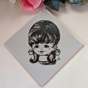 May include: Black and white illustration of a girl with a short bob haircut and pigtails. The girl is wearing a collared shirt and has a sweet expression on her face.