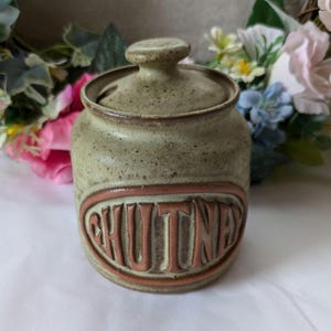 May include: A green ceramic chutney jar with a brown lid and the word "CHUTNEY" embossed on the front.