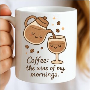 Puede incluir: Taza de café de cerámica blanca con una ilustración caprichosa de una cafetera vertiendo en una copa de vino, rodeada de granos de café y estrellas. El texto dice: "Coffee: the wine of my mornings."