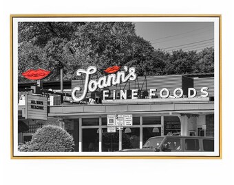 May include: Black and white photograph of a store front with a neon sign that reads "Joann's Fine Foods". The sign has a red lipstick kiss mark on it. The store front has a sign that reads "All Ways Welcome".