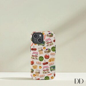 May include: A phone case with a repeating pattern of watercolor illustrations of farmers market scenes. The design includes market stalls, produce, and baskets of fruits and vegetables in shades of red, green, orange, and yellow on a beige background.