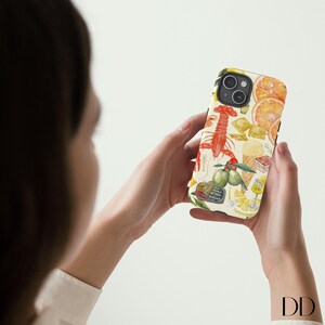 Pode incluir: Uma capa de telefone branca com uma ilustra&ccedil;&atilde;o colorida de lim&otilde;es, limas, frutos do mar e outros alimentos italianos. A capa tem uma borda preta.