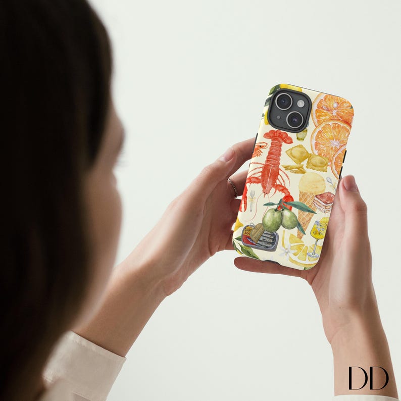 Pode incluir: Uma capa de telefone branca com uma ilustra&ccedil;&atilde;o colorida de lim&otilde;es, limas, frutos do mar e outros alimentos italianos. A capa tem uma borda preta.